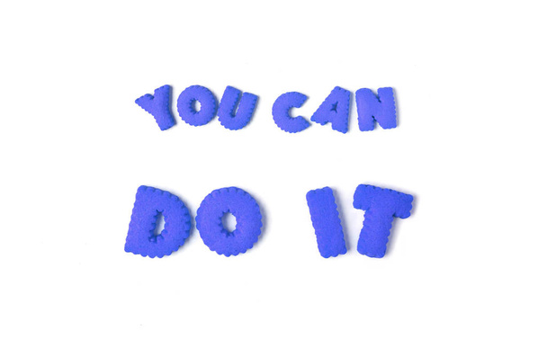 A "You Can Do It" szót kék ábécé alakú sütikkel írják, fehér alapon. - Fotó, kép