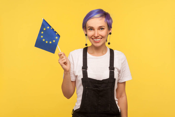 European union flag. Portrait of cheerful hipster girl holding E - Foto, afbeelding