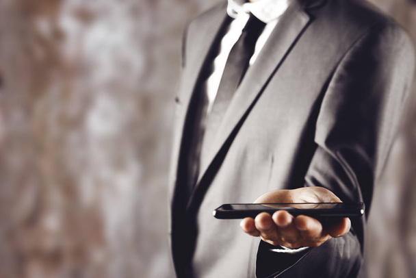 businessman holds phone in hand - Foto, Imagen