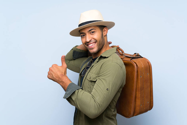 Young handsome man holding a vintage briefcase over isolated blue background - Foto, immagini