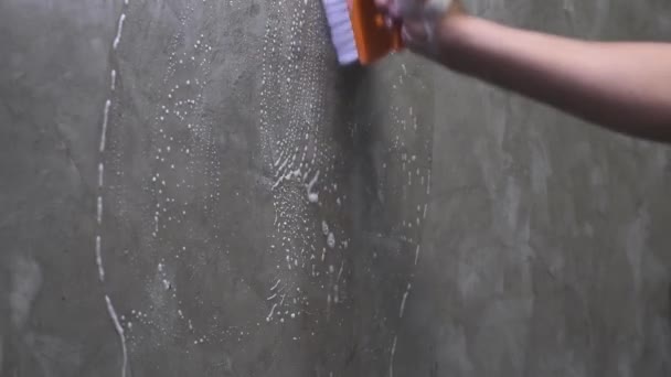 As mãos dos homens são usadas para converter a limpeza de polimento na parede de concreto
. - Filmagem, Vídeo