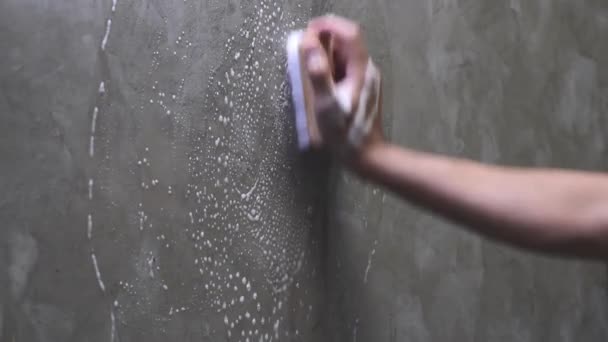 Le mani degli uomini sono utilizzate per convertire la pulizia lucidatura sul muro di cemento
. - Filmati, video