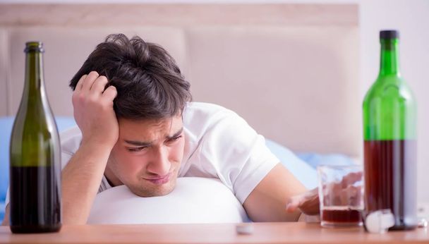 Muž alkoholické pití v posteli prochází rozchod deprese - Fotografie, Obrázek