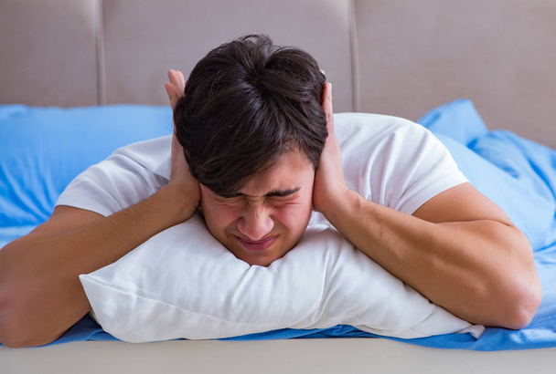 Man suffering from insomnia lying in bed - Valokuva, kuva