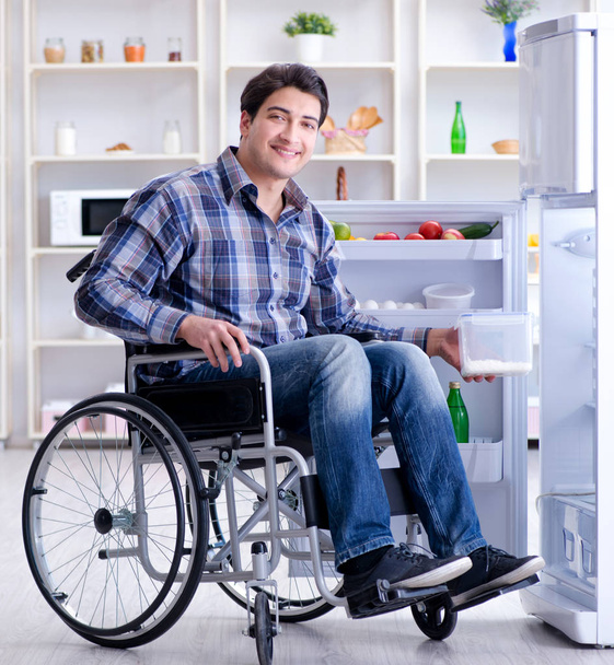 Giovane disabile ferito che apre la porta del frigo - Foto, immagini