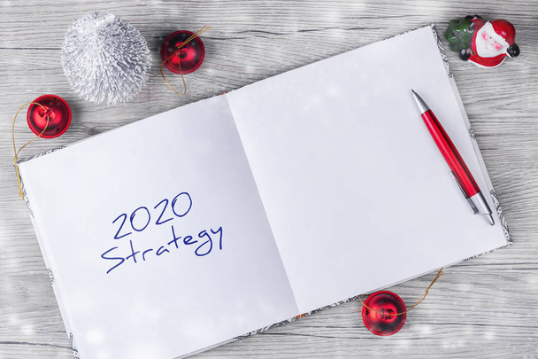 2020年。戦略だ新年のアイデアや目標の概念。木製のテーブルにお祝いの装飾が施されたメモ帳。コピースペース仕事だ戦略. - 写真・画像