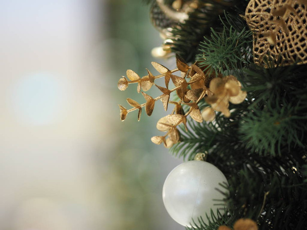 Vánoční ozdoby mají bílou kouli, zlaté listy na rozmazaném pozadí - Fotografie, Obrázek