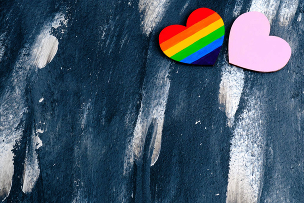 Vista superior del corazón coloreado en colores LGBT orgullo cerca del corazón rosa tradicional en el fondo abstracto. Concepto de San Valentín
 - Foto, Imagen