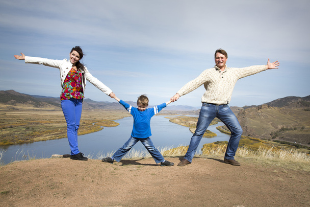 Happy family holding hands together on the mountain - Foto, afbeelding