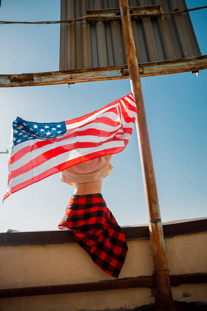 Young woman sitting with flag on roof - Foto, Imagem