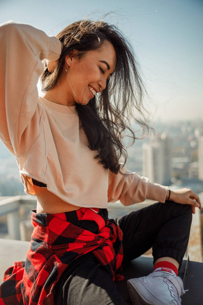 Pretty Asian lady is laughing on the roof - Фото, изображение