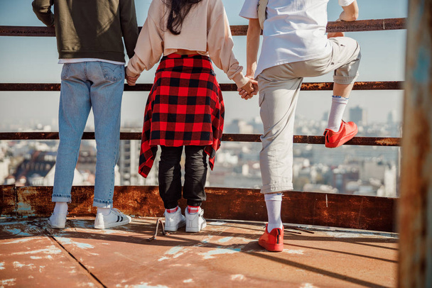 Young friends holding hands on the roof - Foto, Imagen
