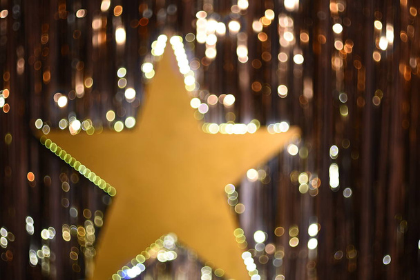 Christmas gold background. Golden holiday glowing background. Defocused background with luminous star. - Фото, изображение
