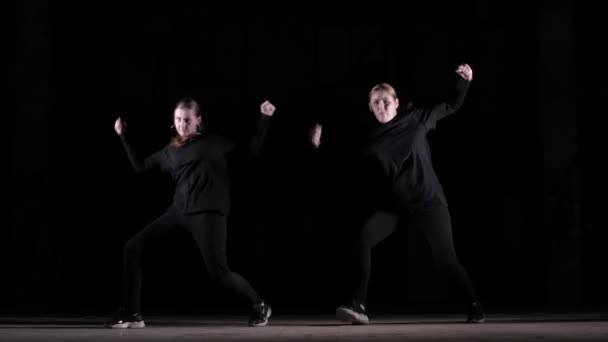 duett fiatal gyönyörű nők táncoló hip hop, utcai tánc egy fekete háttér a stúdióban, elszigetelt - Felvétel, videó