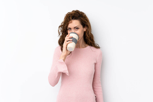 Młoda piękna kobieta na odosobnionym tle trzymając i pijąc kawę, aby zabrać - Zdjęcie, obraz