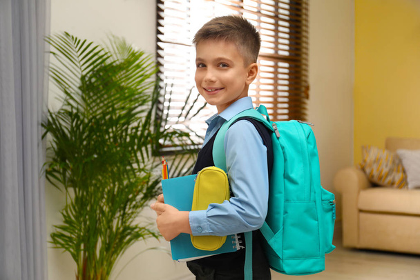 Little boy in uniform with school stationery at home - Zdjęcie, obraz