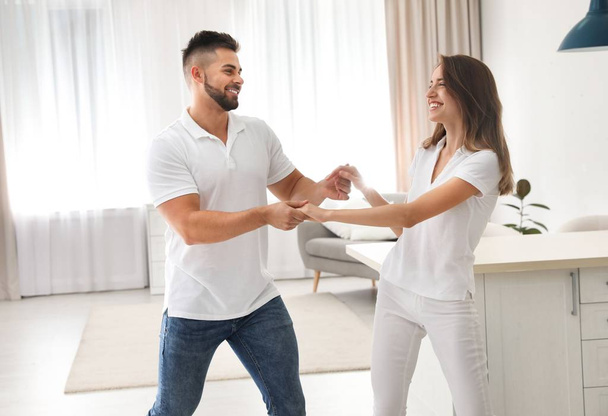 Lovely young couple dancing in kitchen at home - Φωτογραφία, εικόνα