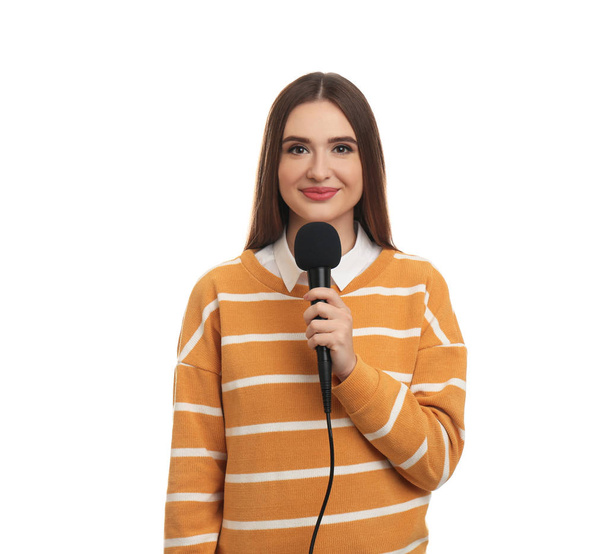 Young female journalist with microphone on white background - Foto, Imagen