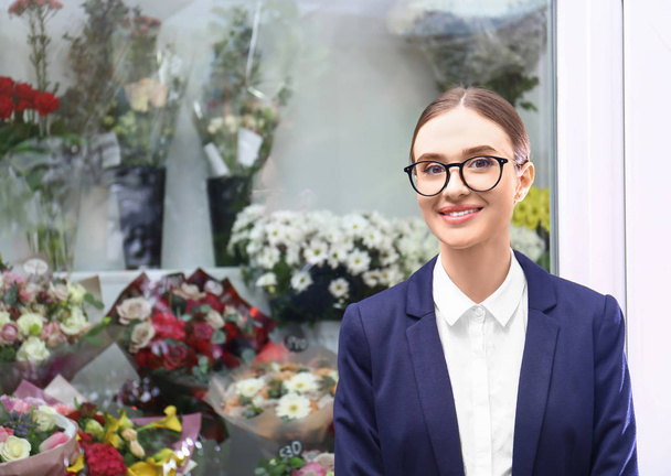 Портрет предпринимательницы рядом с цветочным магазином
 - Фото, изображение