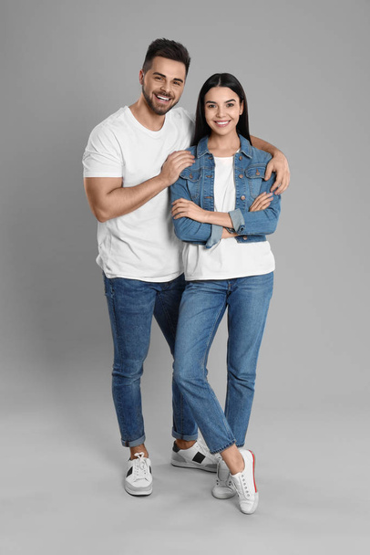 junges Paar in stylischen Jeans auf grauem Hintergrund - Foto, Bild