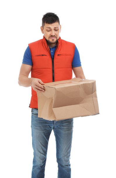 Emotional courier with damaged cardboard box on white background. Poor quality delivery service - Fotografie, Obrázek