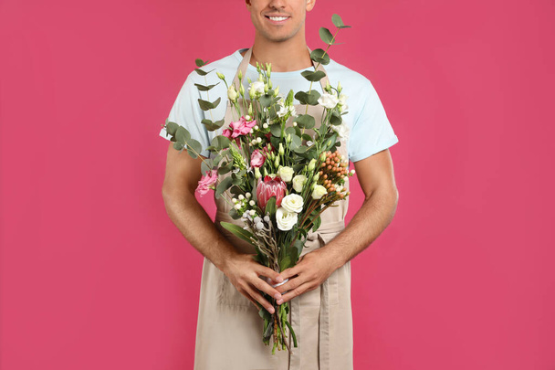 Florist with beautiful bouquet on pink background, closeup - Photo, Image