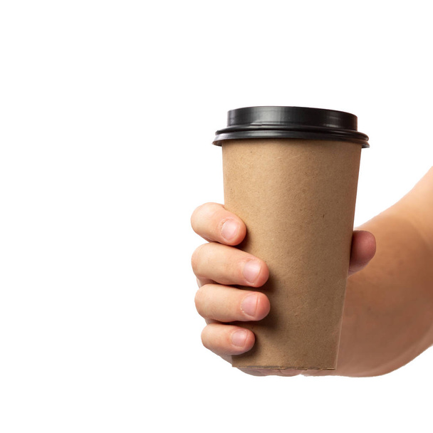 Człowiek ręka gospodarstwa brązowy papierowy kubek kawy z czarną pokrywą izolowane na białym tle. - Zdjęcie, obraz