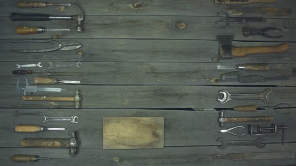 Nástroje pro dřevo a kov. Samčí ruka položí na stůl hřebík a kladivo, na stole jsou různé kovové a tesařské nástroje pro zpracování dřeva a kovu. - Záběry, video