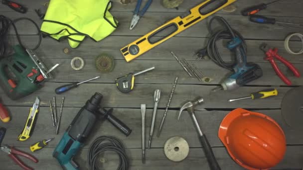 A variety of electro and hand tools and special clothing. Top view. On the table are tools for various types of construction and repair work on wood, metal, concrete, plastic and other materials. The camera moves from right to left. - Footage, Video