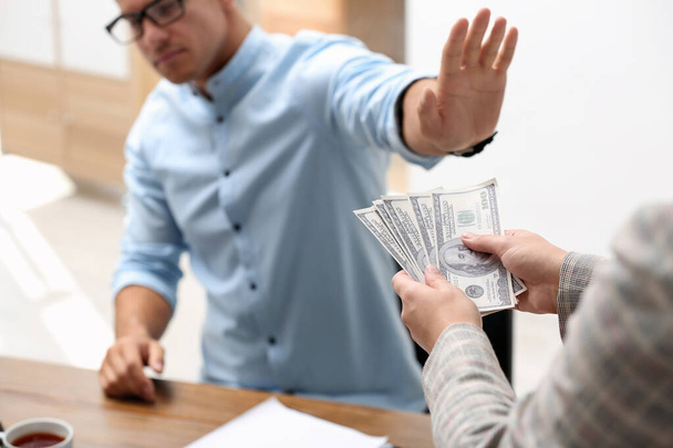 Man refuses to take bribe money at table in office, closeup - Φωτογραφία, εικόνα
