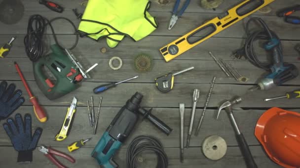 A variety of electro and hand tools and special clothing. Top view.On the table are tools for various types of construction and repair work on wood, metal, concrete, plastic and other materials.The camera moves from left to right. - Footage, Video
