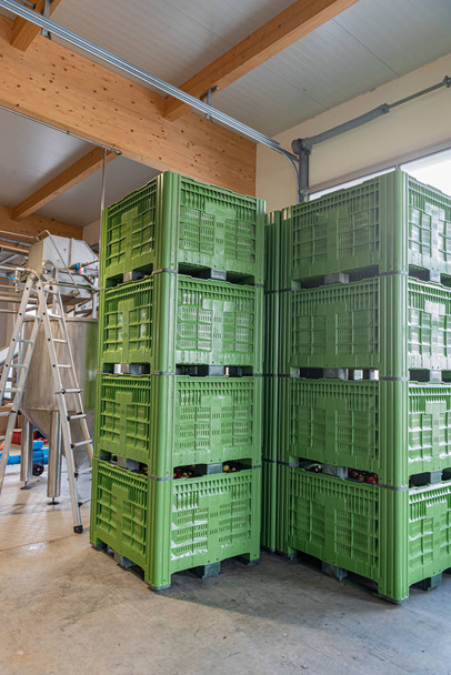 grüne Kisten übereinander gestapelt in einem Industriegebäude - Foto, Bild