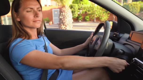 Frau in blauem Kleid startet Auto, stellt aber fest, dass es kaputt ist - Filmmaterial, Video