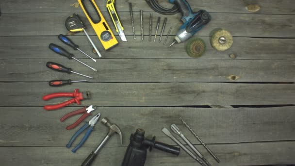 A variety of electro and hand tools and live gloves. Stop motion animation. Top view. Gloves bring a hammer into a circle of tools and it starts to rotate. Then they pick him up. - Footage, Video