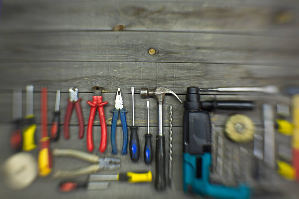 Na stole znajdują się narzędzia do różnego rodzaju prac budowlanych i remontowych na drewnie, metalu, betonie, tworzywach sztucznych i innych materiałach.. - Zdjęcie, obraz