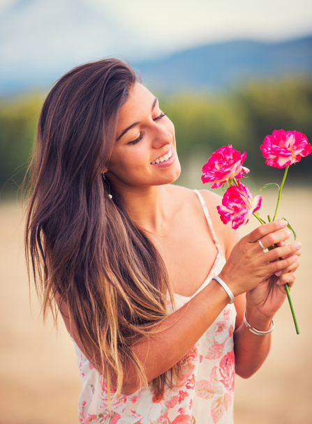Woman smelling flowers in nature - Фото, изображение