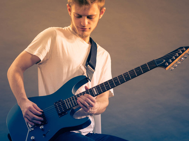 Young man playing electric guitar - Valokuva, kuva