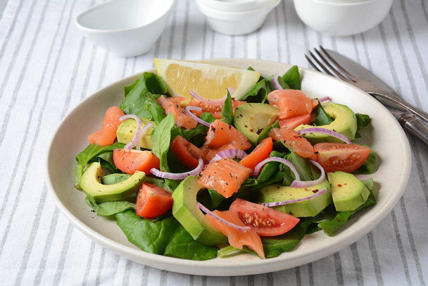 Mediterranean Avocado Salmon Salad with spinach, cherry tomatoes, avocado and red onion dressing. Concept for a tasty and healthy meal. Vegan food - Photo, image