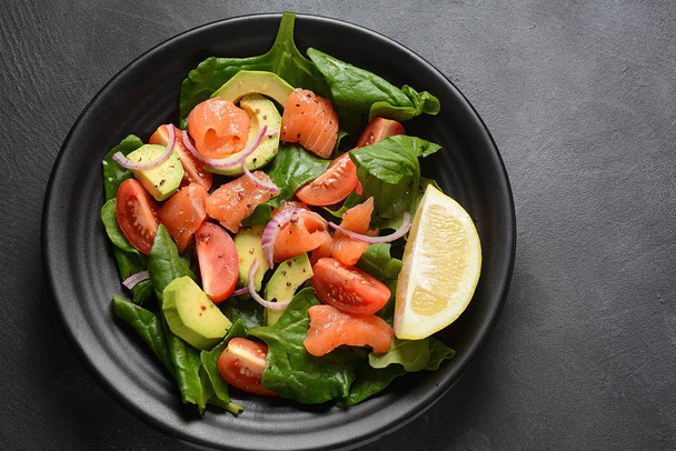 Mediterranean Avocado Salmon Salad with spinach, cherry tomatoes, avocado and red onion dressing. Concept for a tasty and healthy meal. Vegan food - Фото, изображение