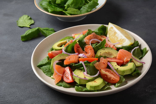 Mediterranean Avocado Salmon Salad with spinach, cherry tomatoes, avocado and red onion dressing. Concept for a tasty and healthy meal. Vegan food - Photo, image