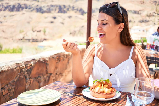 Jeune belle femme assise au restaurant profitant de vacances d'été manger de la nourriture délicieuse
 - Photo, image