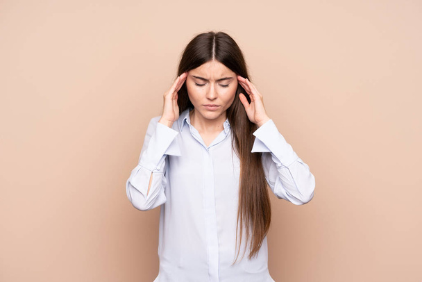 Jonge vrouw over geïsoleerde achtergrond met hoofdpijn - Foto, afbeelding
