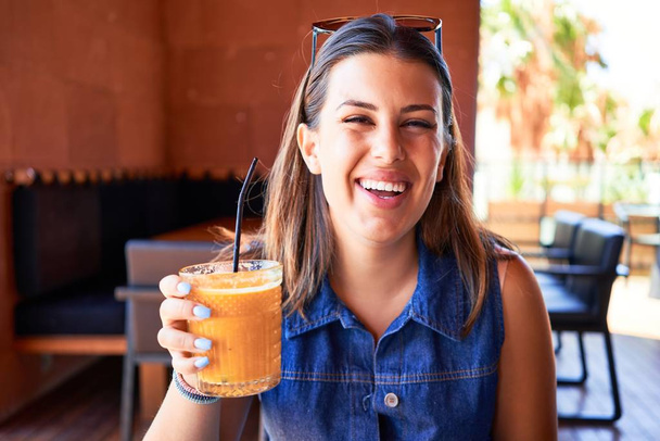 Fiatal gyönyörű nő ül az étteremben élvezi a nyári vakáció ivás egészséges smoothie - Fotó, kép