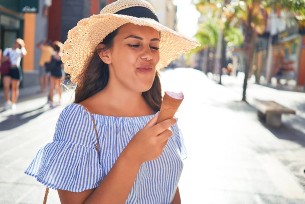 Jeune belle femme mangeant un cône de crème glacée marchant dans la rue de Tenerife par une journée ensoleillée d'été pendant les vacances
 - Photo, image