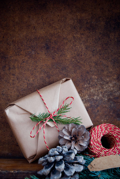 Christmas gift decorated with pine cones and spruce branches  - Photo, Image