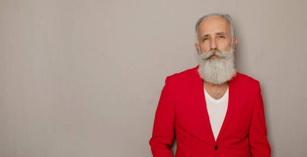 Bearded senior man wearing red suit on grey background. Trendy mature men. - Foto, Bild
