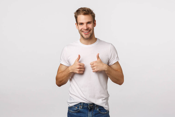 Nice job, congratulations. Happy and satisfied good-looking blond guy with bristle show thumbs-up in approval, like or recommendation gesture, smiling pleased, agree, encourage friend made good job - Фото, зображення