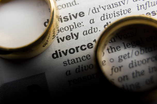 Концепция развода и развода. Два золотых обручальных кольца. Определение словаря
 - Фото, изображение