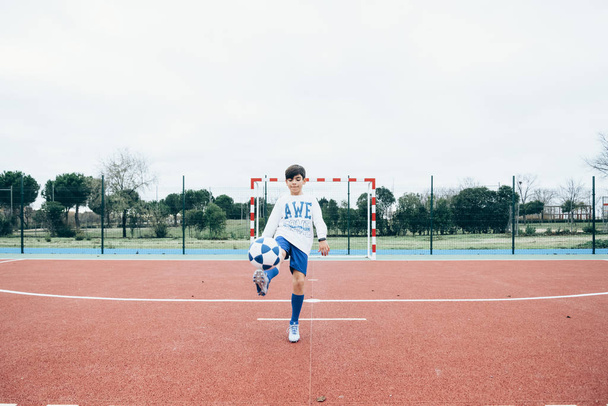 Jugador de fútbol chico golpeando la pelota
 - Foto, imagen
