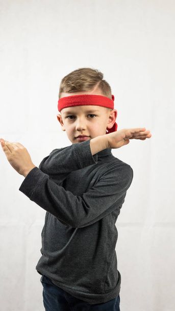 little karate player. boy in dark golf. and red headbands. on a white background - 写真・画像